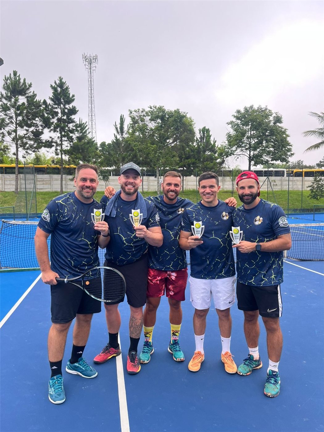 Jogadores na quadra com os troféus do torneio